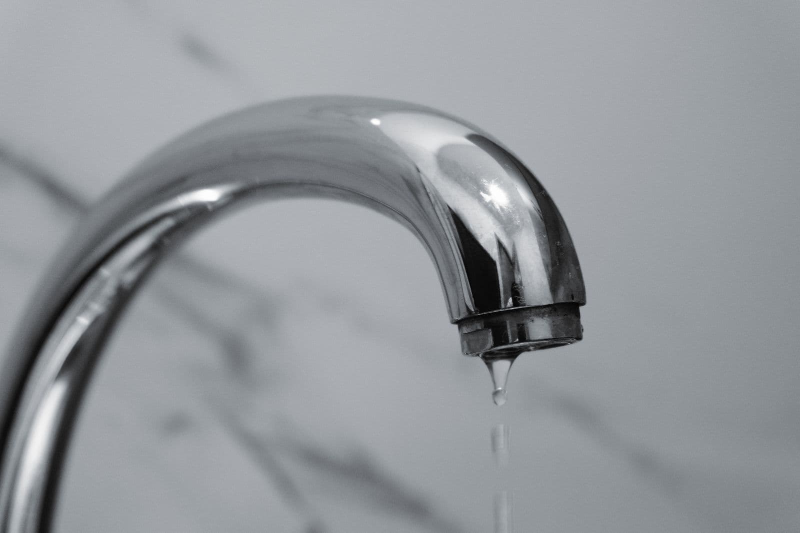 Water dripping from a chrome faucet