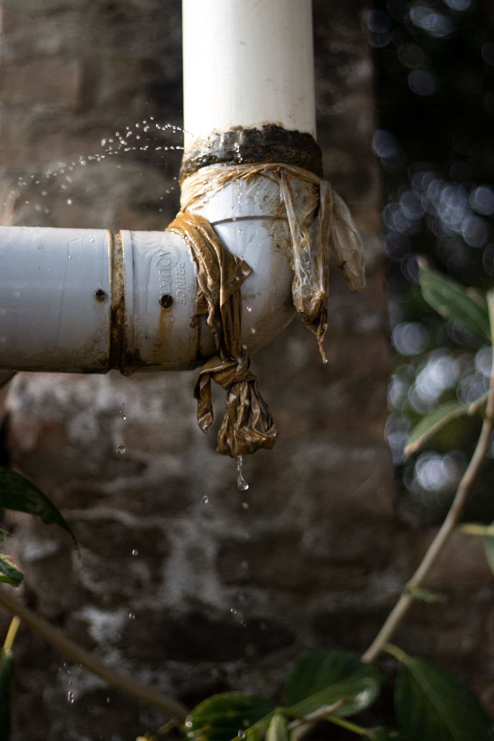Leaking pipe temporarily wrapped in plastic and tape